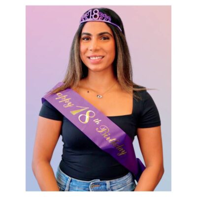 Woman wearing the Happy 18th Birthday Deluxe Crown & Sash Set with a sparkling purple 18 tiara and matching purple sash with gold lettering.