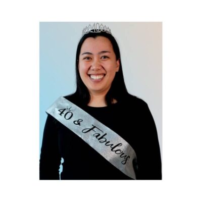 Woman wearing a silver "40 & Fabulous" birthday sash for a 40th birthday celebration.